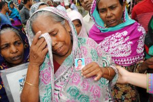 Two years after the collapse of the factory at Rana Plaza, families of victims gather, holding photos of their lost loved ones. (Amy Yee for NPR)