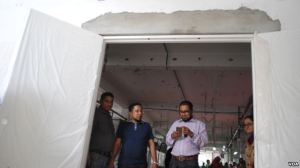 Managers at Alif Embroidery Village walk through a new fire door that was imported and meets international standards. (Amy Yee/VOA)